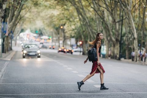 young woman crossing city street