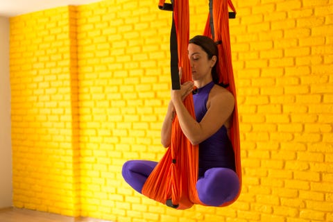 ung kvinne som gjør antigravity yoga