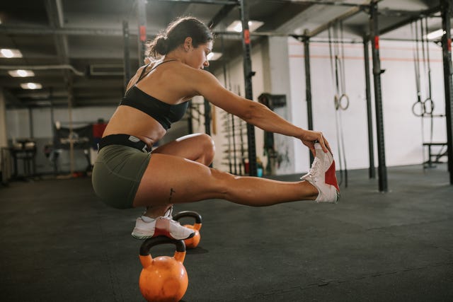 A woman performs a squat with a gun woman doing a squat with a gun