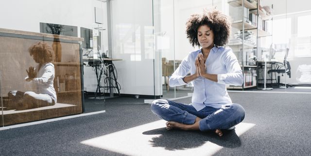 young woman doing yoga in office