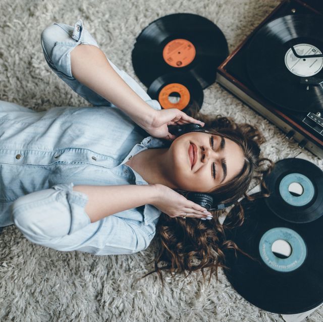 Young woman enjoing music from gramophone