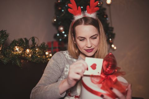 young woman enjoying christmas and opening presents