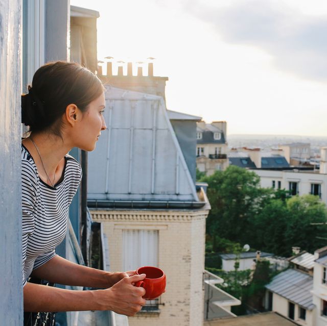 young woman enjoying the view from a parisian apartment