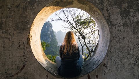young woman enjoys view over yangshuo, karst mountains