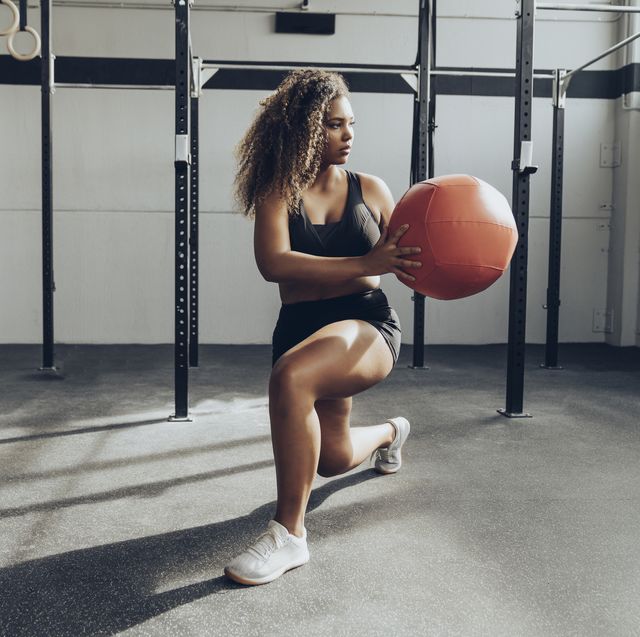 young woman exercising  with medicine ball in gym