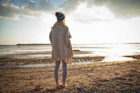 ドーセット州ボーンマス・ビーチを眺める若い女性。 UK