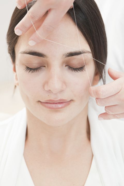 young woman having eyebrows Threaded