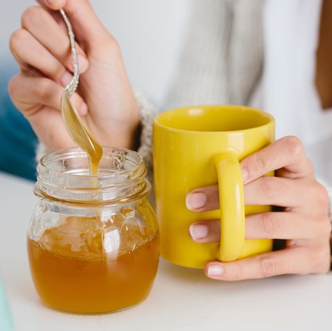 Young woman having honey drink