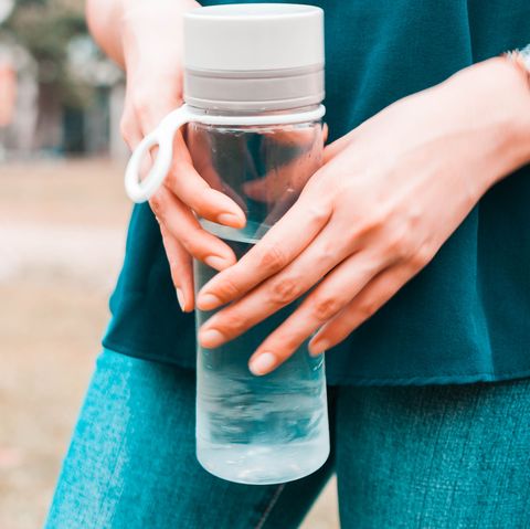 Woman holds reusable water bottle