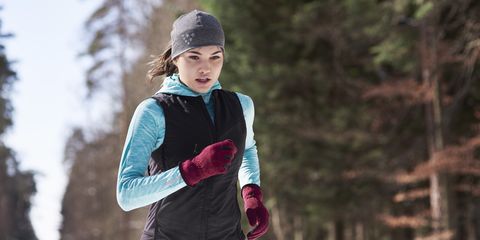 Young woman jogging in winter forest
