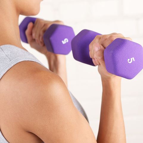 young woman lifting two purple dumbbells