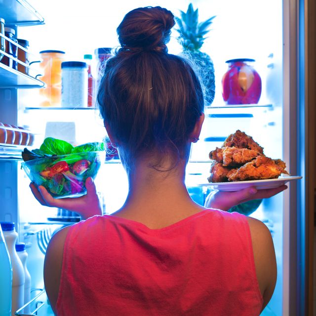 young woman making choices for a healthy salad or junk food fried chicken