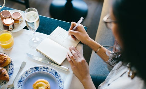 Young woman making notes whilst having champagne breakfast at boutique hotel in Italy Young woman making notes whilst having champagne breakfast at boutique hotel in Italy