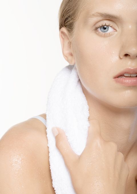 young woman perspiring, with towel around neck