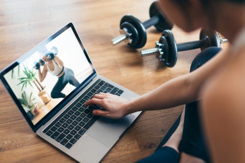 Young Woman Practising Weight Training Workout With A Video Lesson On Laptop. young woman practising weight training workout with a video lesson on laptop
