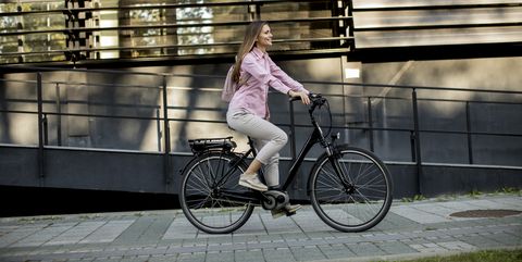young woman riding e bike in urban enviroment