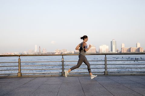 Young woman running along Hudson River