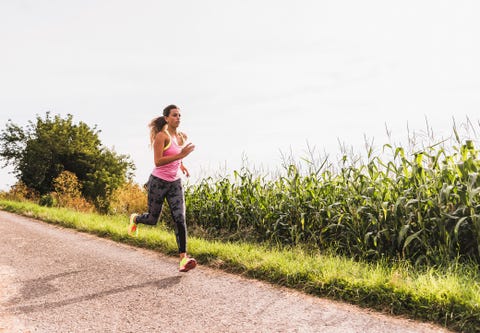 Young woman running on country lane