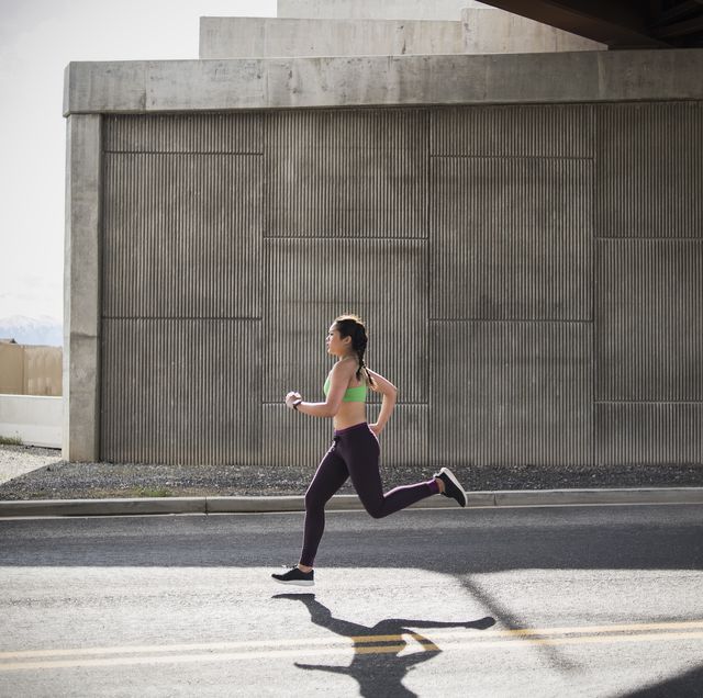 young woman running under freeway overpass