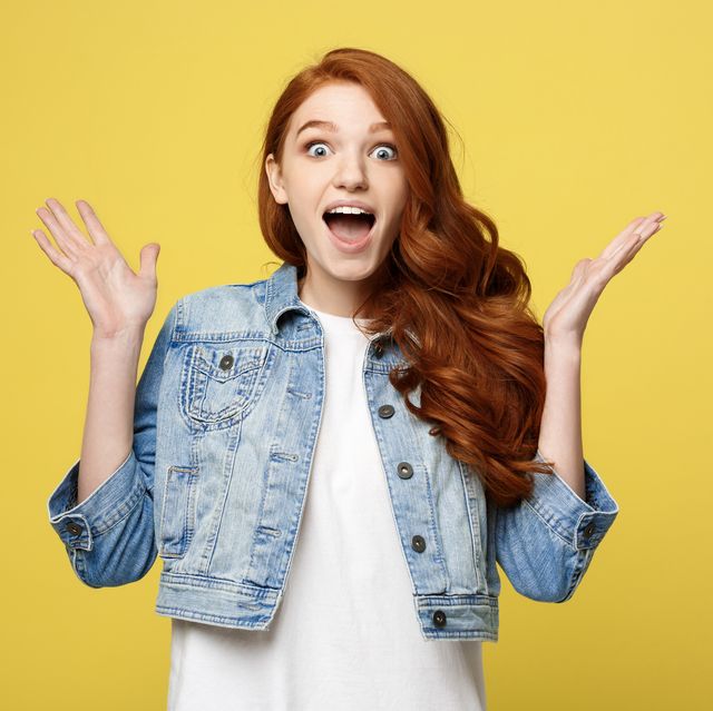 young woman standing against yellow background