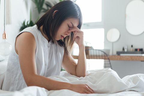 young woman suffering headache in bed