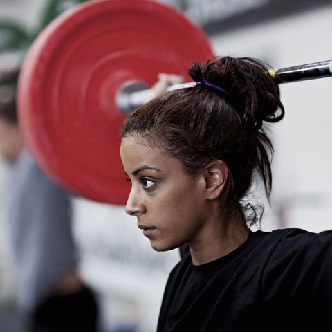 Young woman training with weights