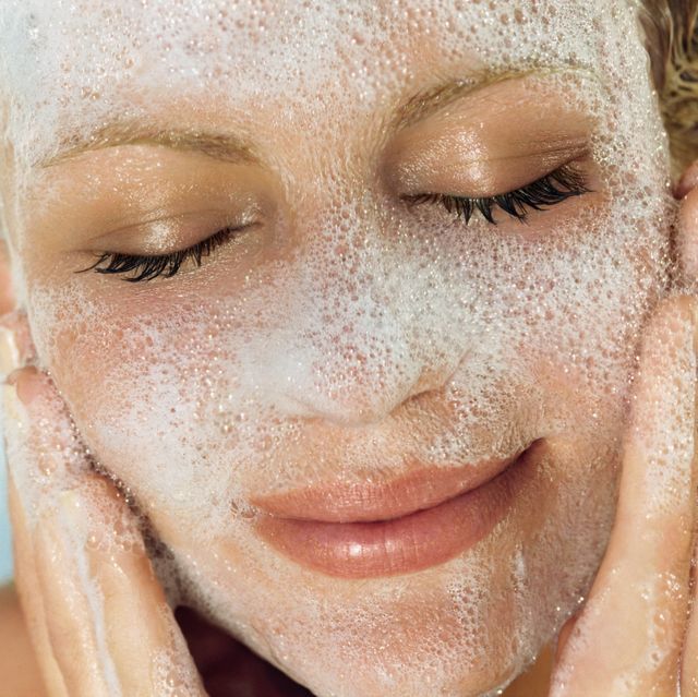 young woman washing face, close up