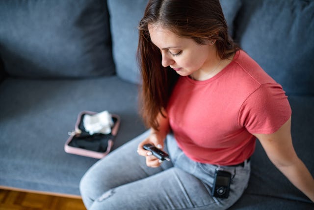 young woman wearing insulin pump and checking glucometer