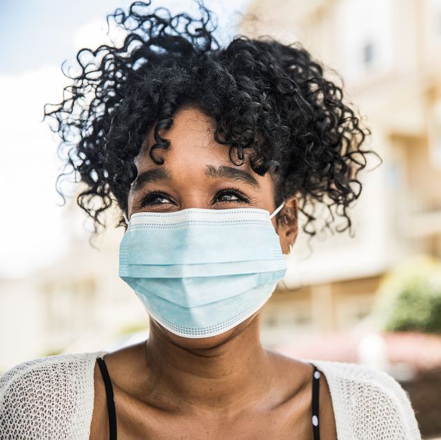 young woman wearing surgical mask in front of home best disposable face masks