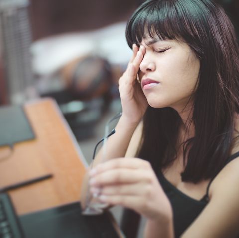 Young woman with aching eyes after working on computer.