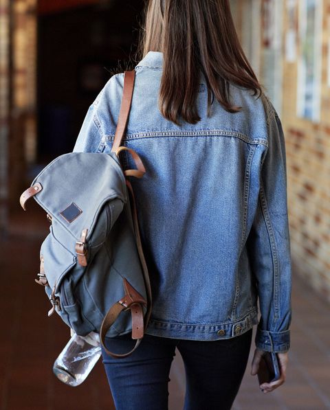 Young woman with backpack walking in corridor