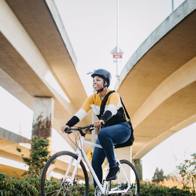 young woman with bike and messenger bag in the city