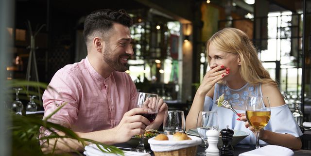 young woman with boyfriend laughing at restaurant table