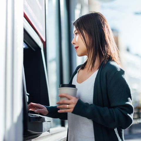 young woman withdrawing cash money at the atm