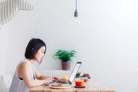 young woman working whilst having breakfast