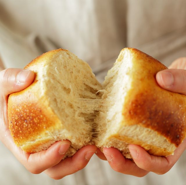 young woman's hands breaking bread,close up