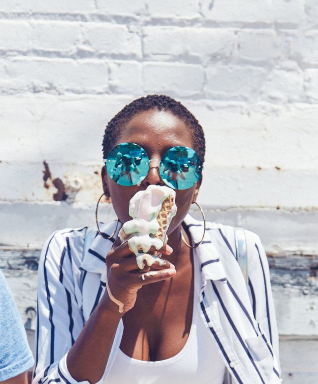 young women eating melting ice cream cone