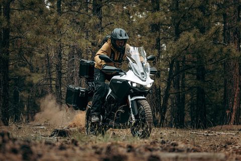 man riding a zero dsrx motorcycle through the woods