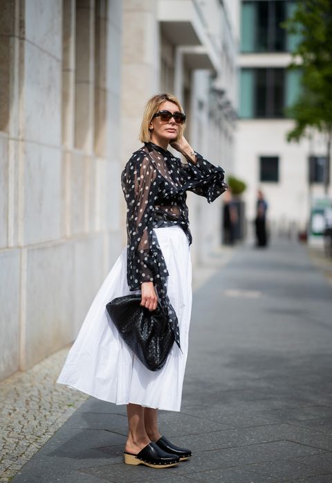 berlin, germany   may 08 victoria nasir is seen wearing white pleated poplin a line skirt cos, transparent blouse with polka dots petar petrov, clogs zara, black the pouch bottega venta, sunglasses marni on may 08, 2019 in berlin, germany photo by christian vieriggetty images