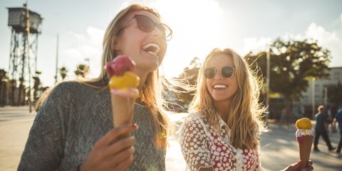Vrouwen eten lachend een ijsje in de zon