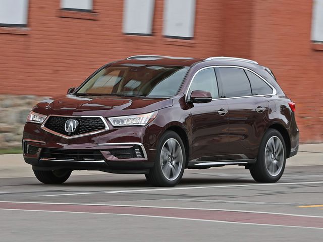 2017 acura mdx driving down a city street