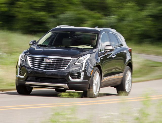 2017 black cadillac xt5 suv driving an empty country road