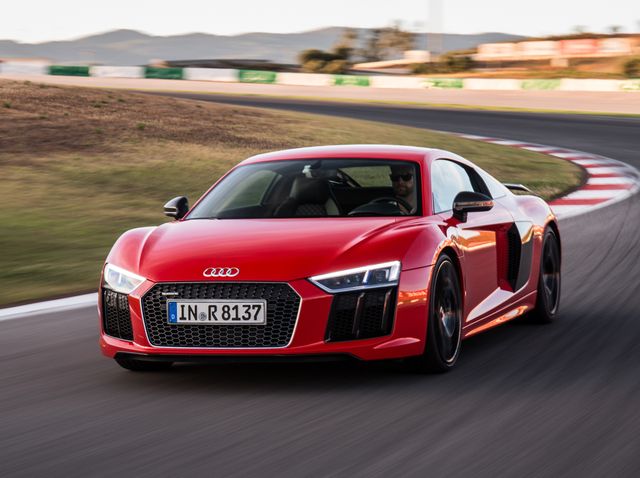 2017 red audi r8 coupe driving around a racetrack