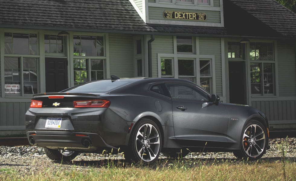 2017 black chevrolet camaro parked near an abandoned train station