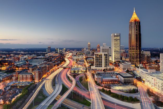The midtown skyline and interstate highway system as it merges into downtown Atlanta in the late evening. Viewable are great light trails from the traffic on the highways, Georgia Tech University, and various midtown skyscrapers.