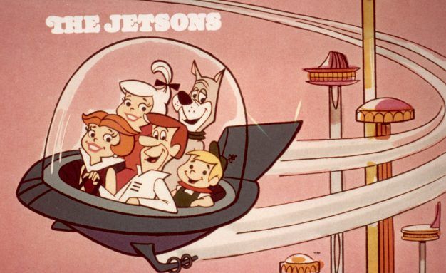 circa 1962: Cartoon family the Jetsons, comprised of George, Jane, Judy, Elroy, and Astro, flying in a space car in a space age city, in a still from the Hanna-Barbera animated television show, 'The Jetsons'. 