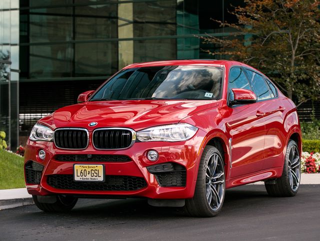 2017 red bmw x6 m suv parked near an office building