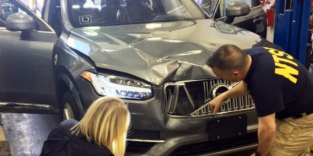 Investigators from the National Transportation Safety Board examine the Volvo XC90 which struck a pedestrian in Tempe, Arizona, on Sunday night.