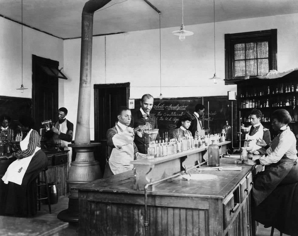 George Washington Carver with students in his laboratory at Tuskegee Institute
