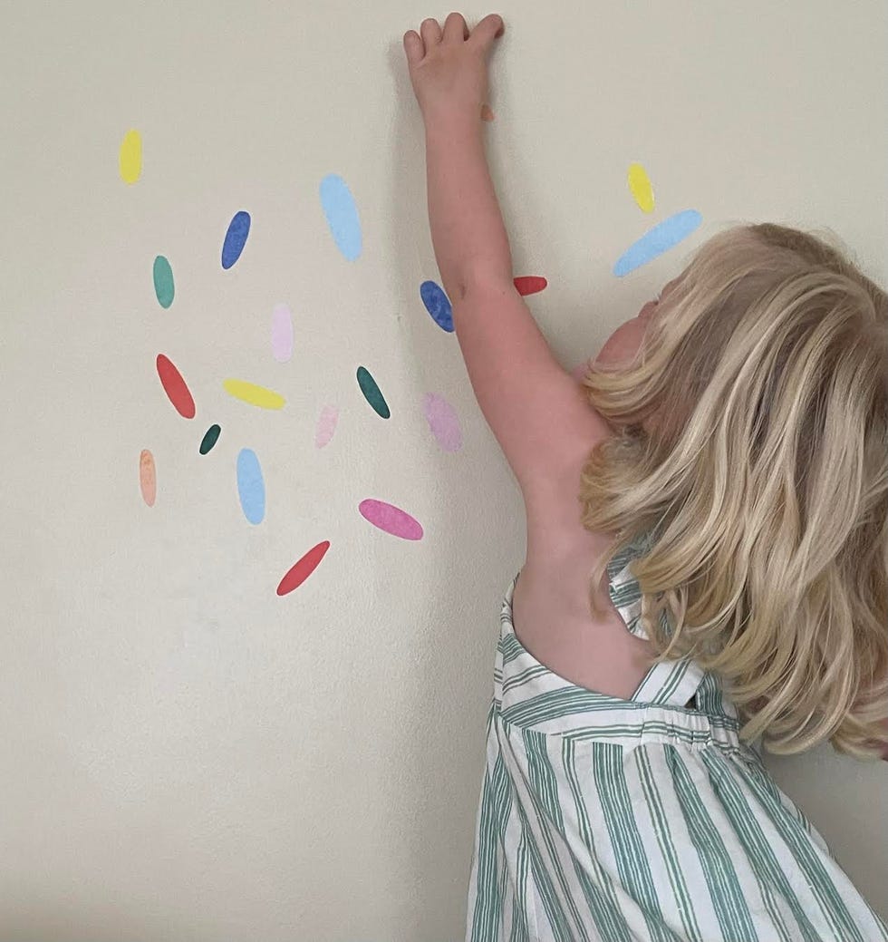 toddler installing wallpaper decals